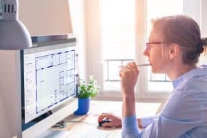 A Woman analyzing a Construction Plan on her Computer