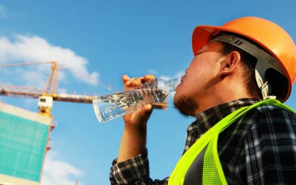 a construction worker drinking water