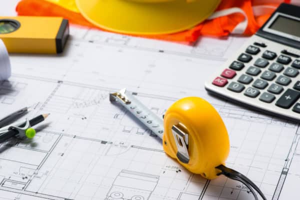 a calculator and a tape measure on construction plans