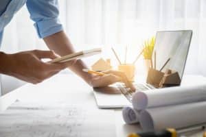 A man working on his laptop on Construction Plans
