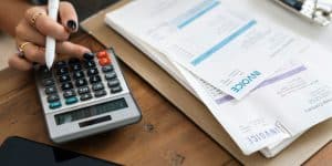 a person working on invoices with a calculator