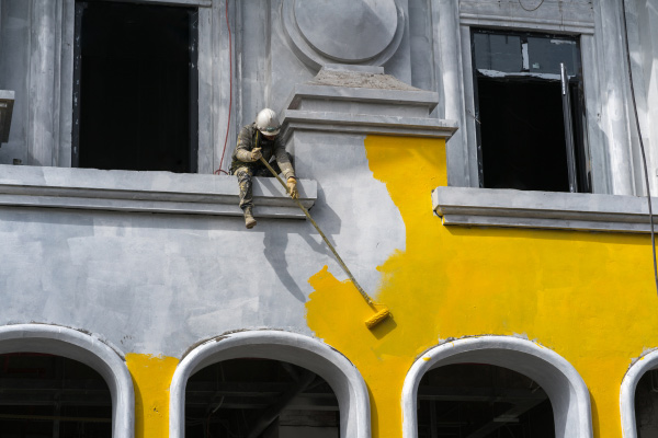 worker in the painting the building